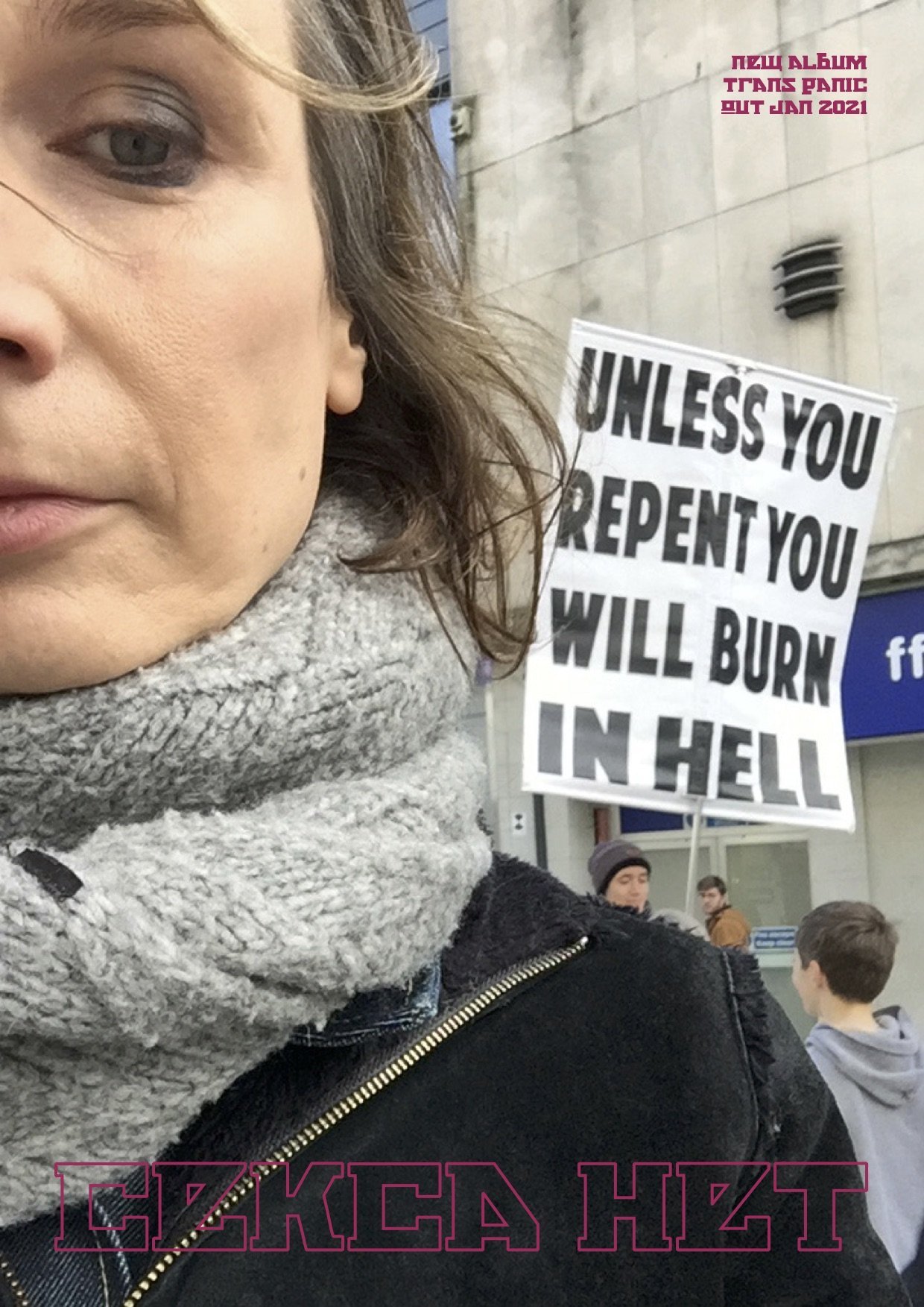 cekca het promo by Cekca Het/Rhiannon Lowe cekca het promo poster, a part of the artist's face can be seen looking into camera with a man in the background holding a 'burn in hell' placard