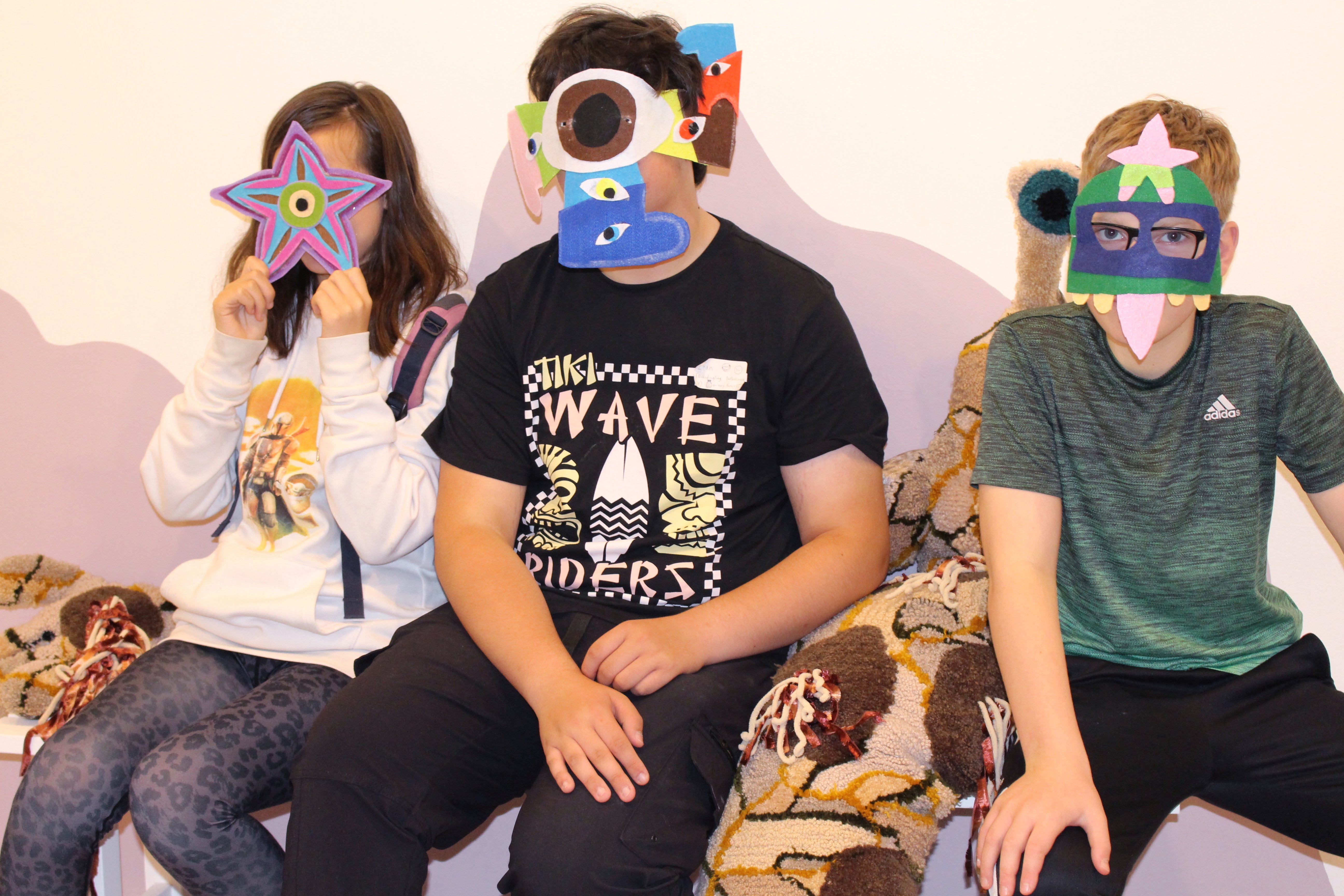 Workshop participants sat next to Non's 'Fail Snail' wearing handmade masks
