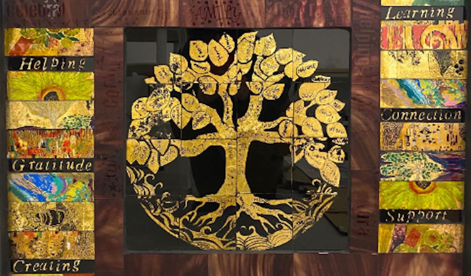 Collaborative glass piece created by workshop participants with artist Lisa Burkl. Image features a gold tree in centre with blocks of colour and wording on each side. Piece is composed of various glass pieces